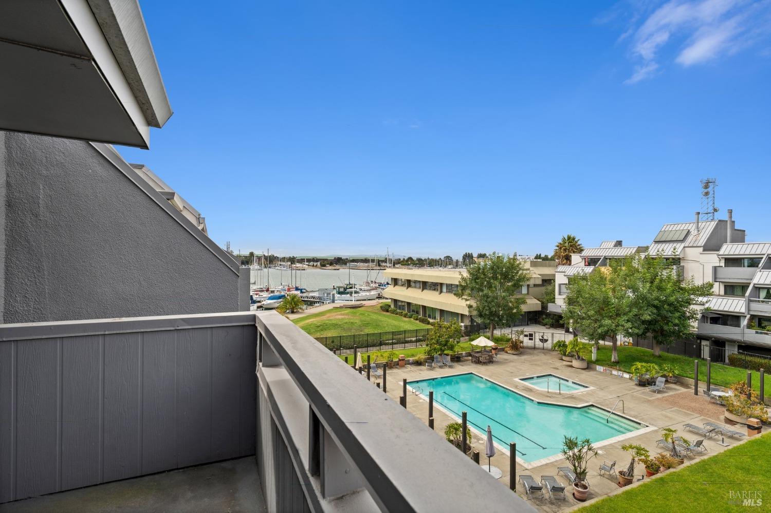 Welcome to your waterfront retreat!  This is a view overlooking to the pool and the Marina area. Experience the joy of watching sailboats glide by from the comfort of your private balcony.