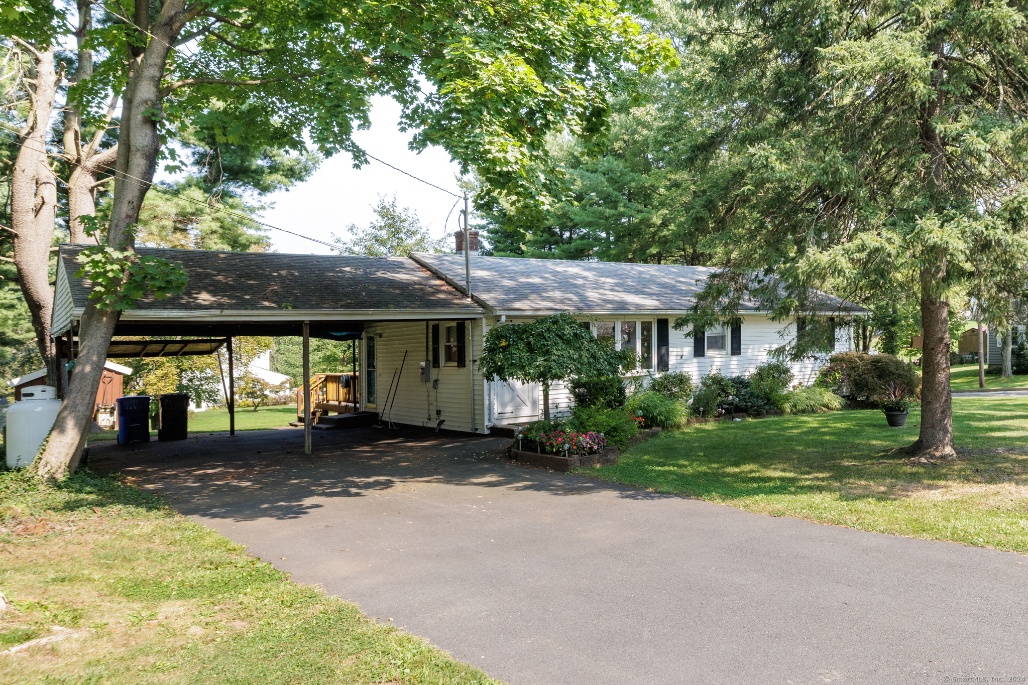 a front view of a house with a garden and tree