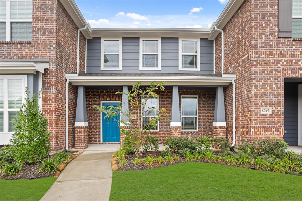 front view of a brick house with a yard