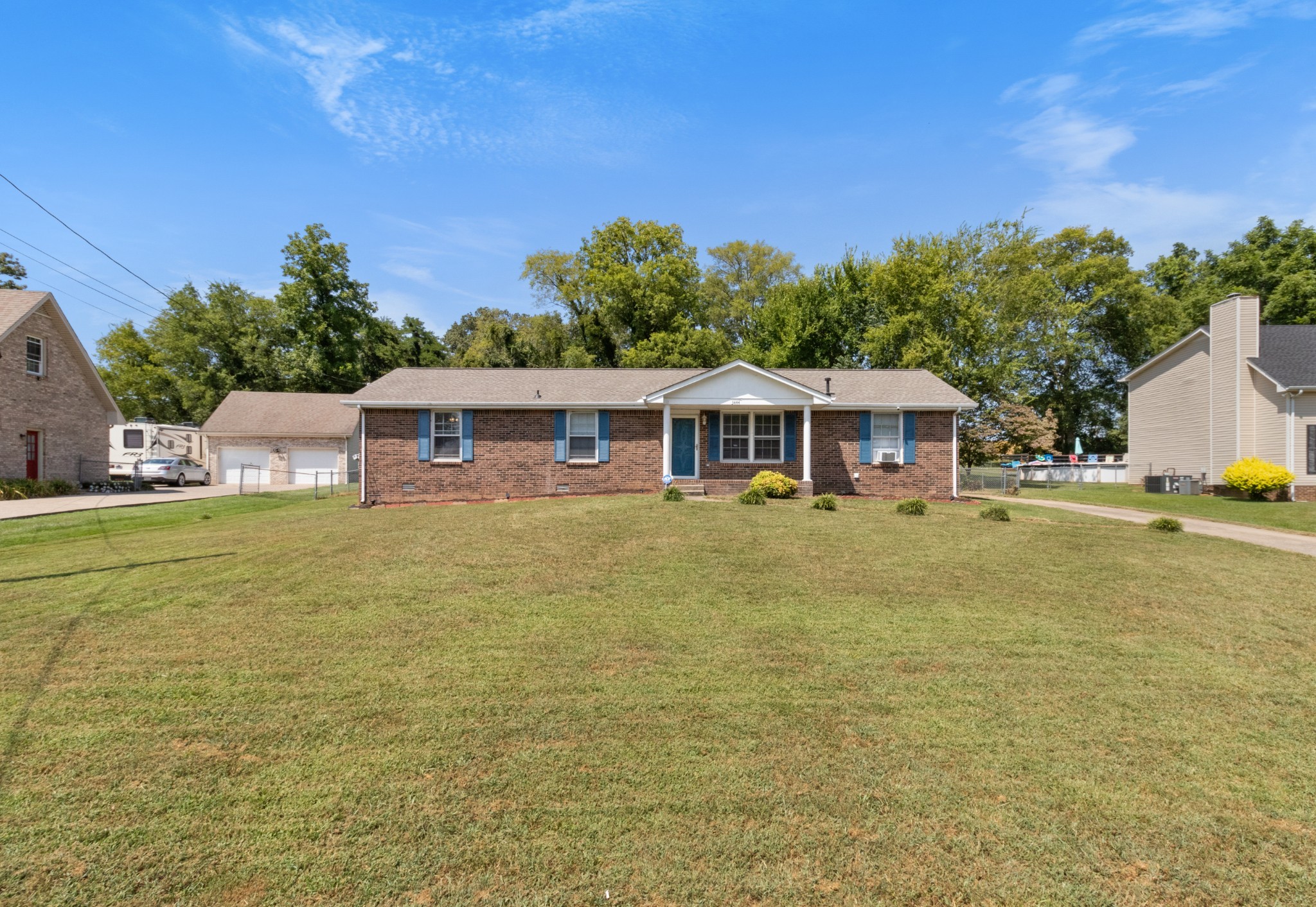 a front view of house with yard and trees in the background