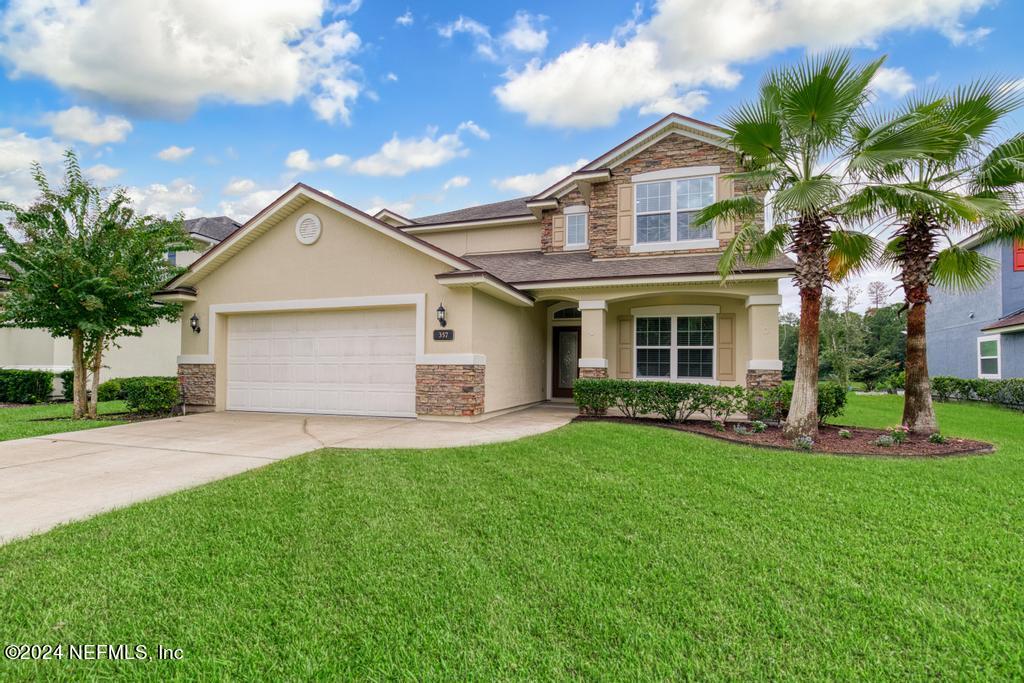 a front view of a house with a yard and garage