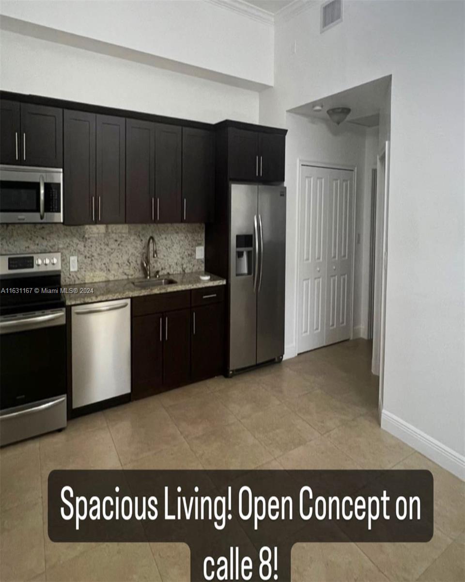 a kitchen with stainless steel appliances granite countertop a refrigerator and a stove