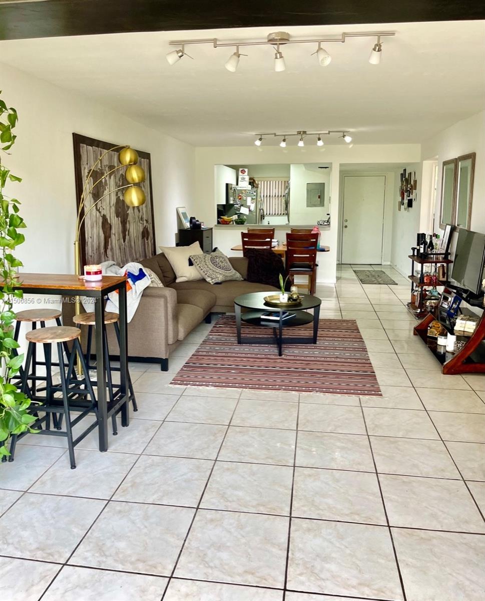 a living room with furniture a table and kitchen view