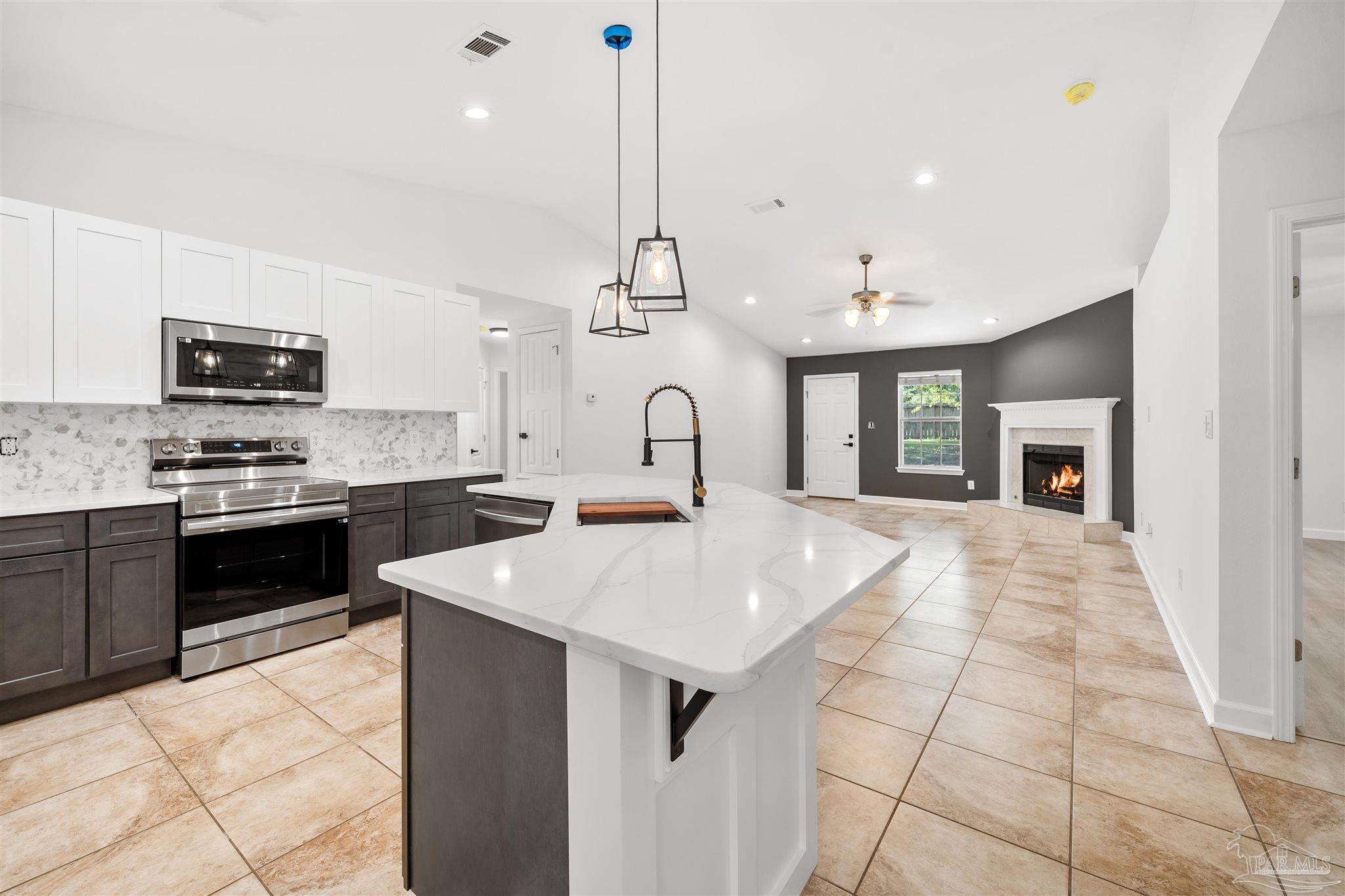 a kitchen with kitchen island a sink appliances and cabinets