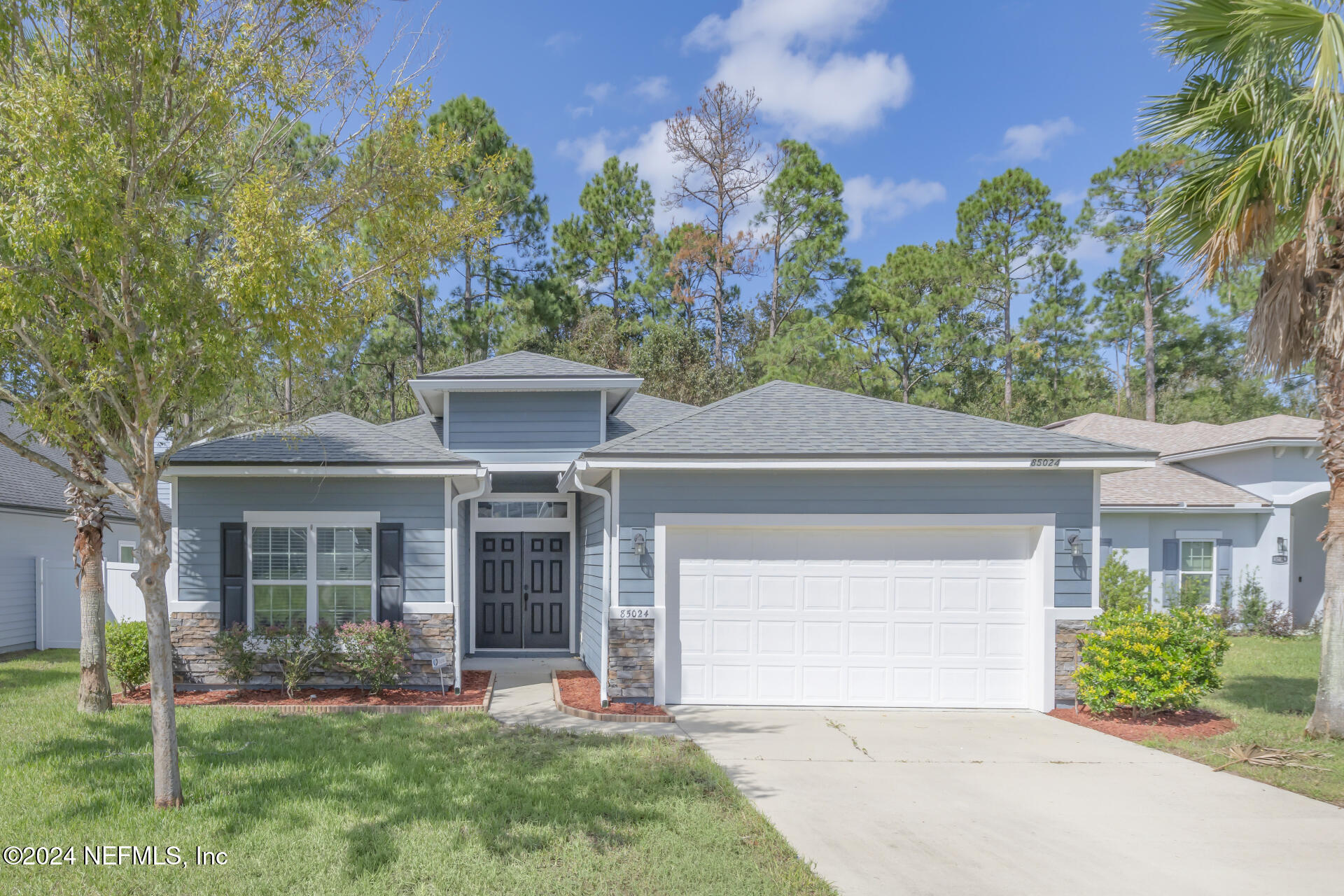 front view of a house with a yard and an trees