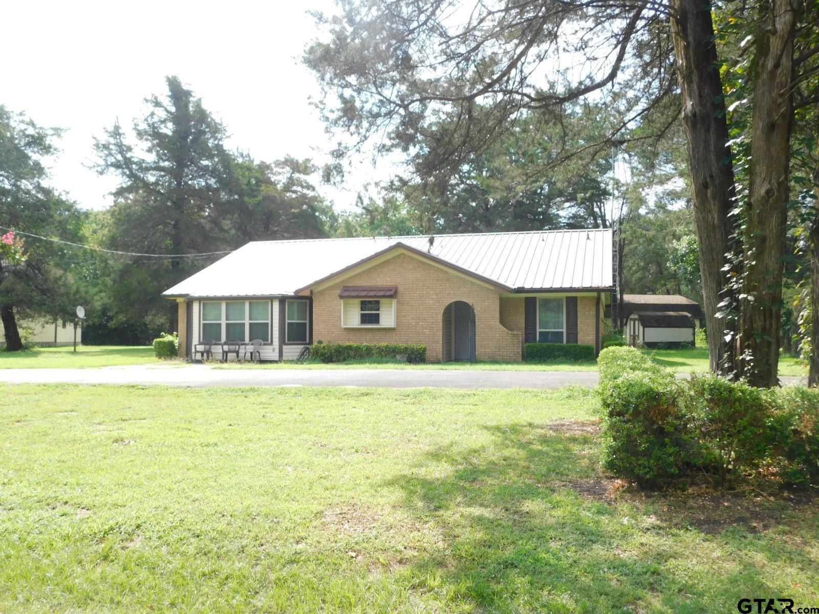 a front view of a house with yard patio and green space