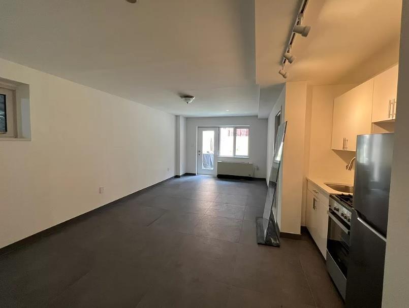 a view of a kitchen with refrigerator and wooden floor