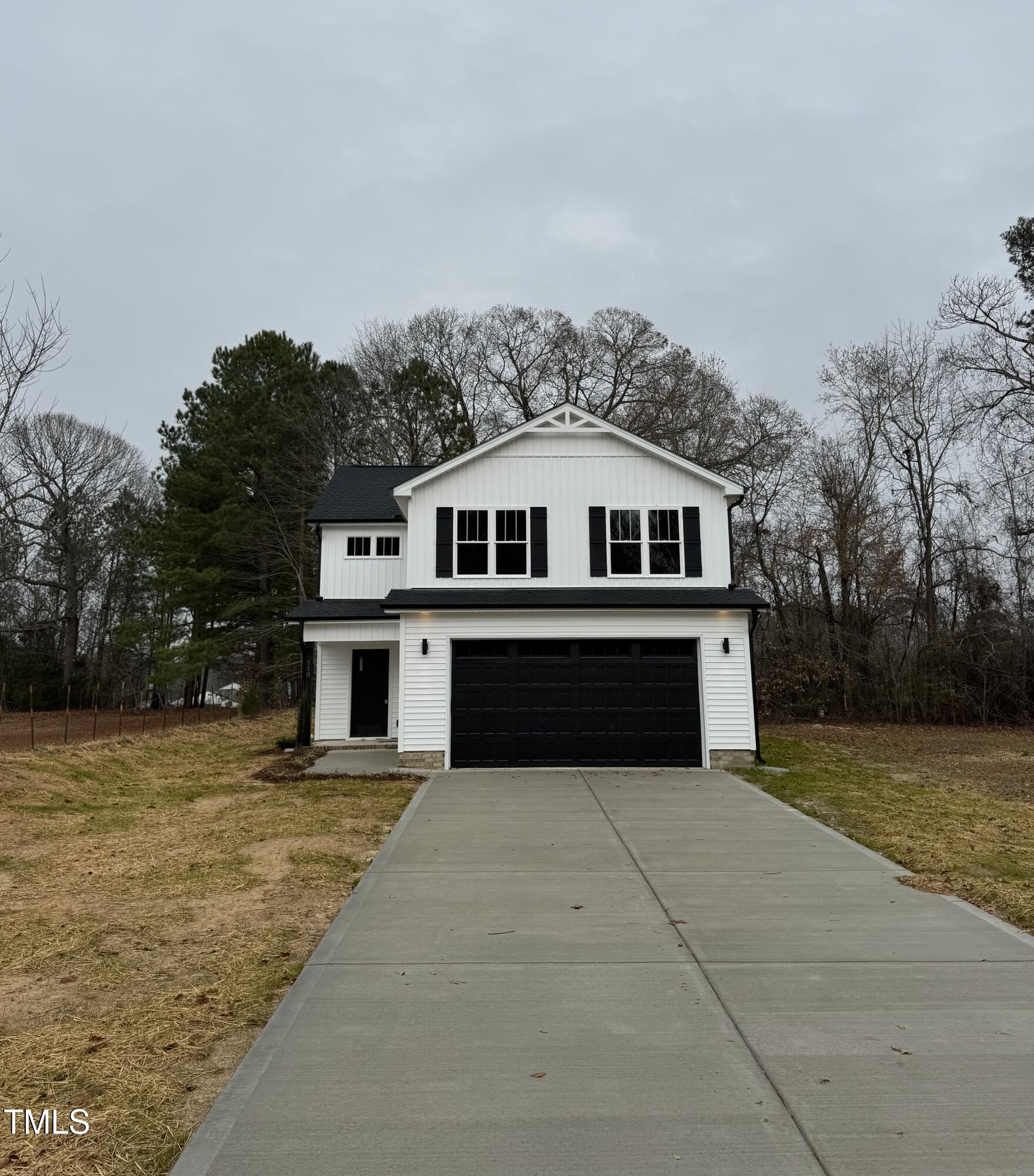 a front view of a house with a yard and trees