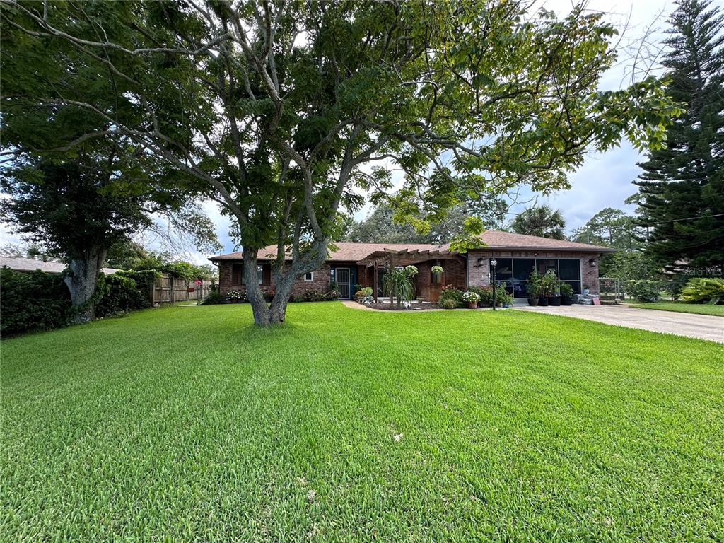 a front view of a house with a garden and trees