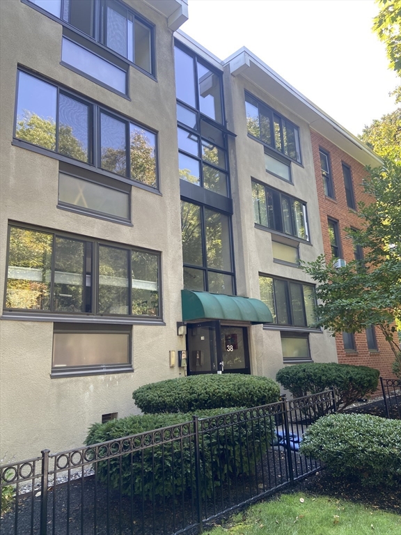 a front view of a multi story residential apartment building with a yard