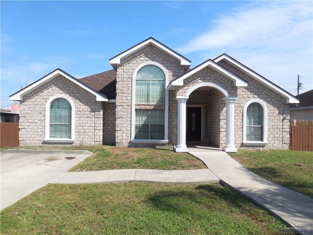 a view of a brick house with a yard