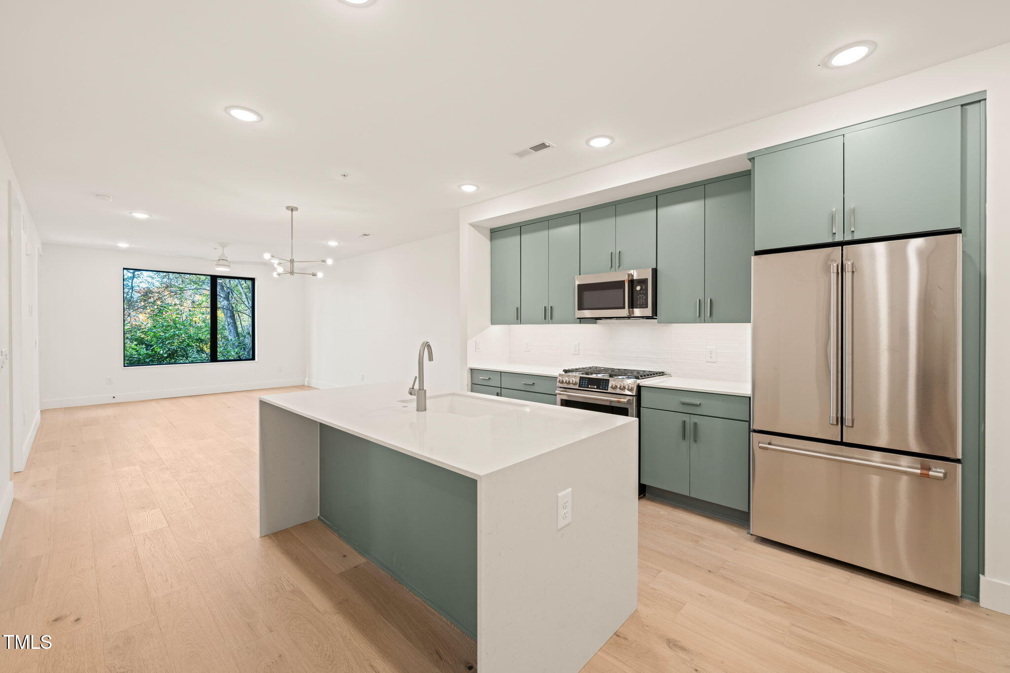 a kitchen with stainless steel appliances a refrigerator sink and microwave