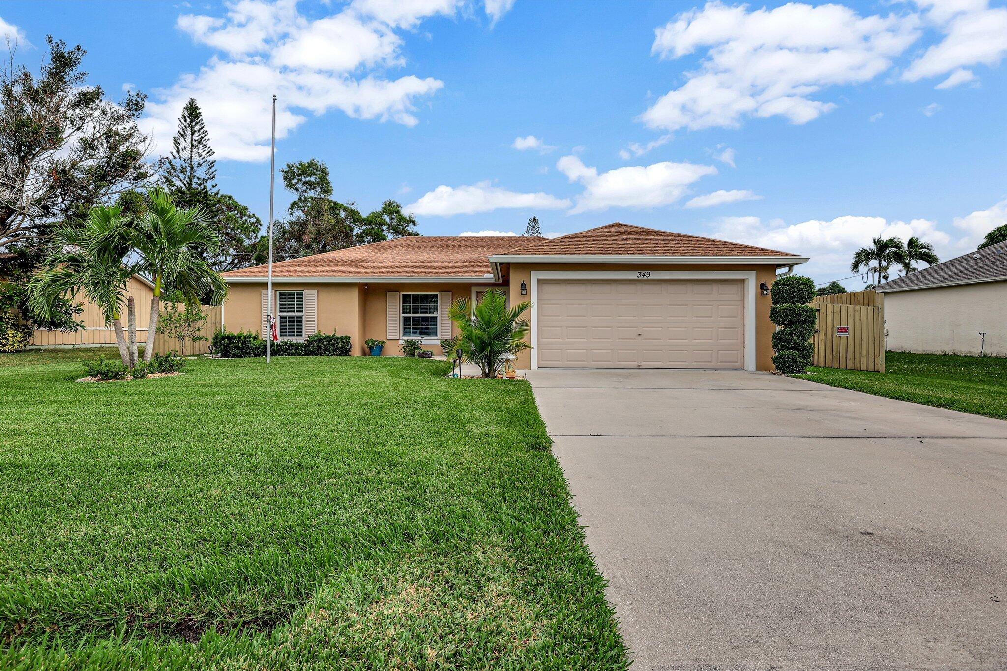 a front view of a house with a yard and trees