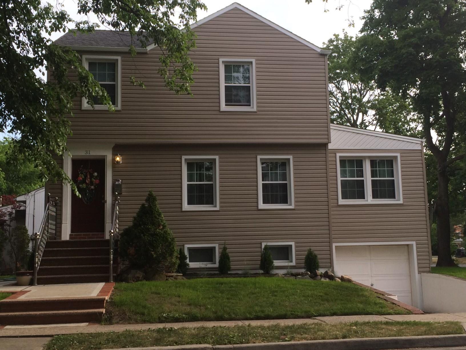 View of front facade featuring a front yard and a garage