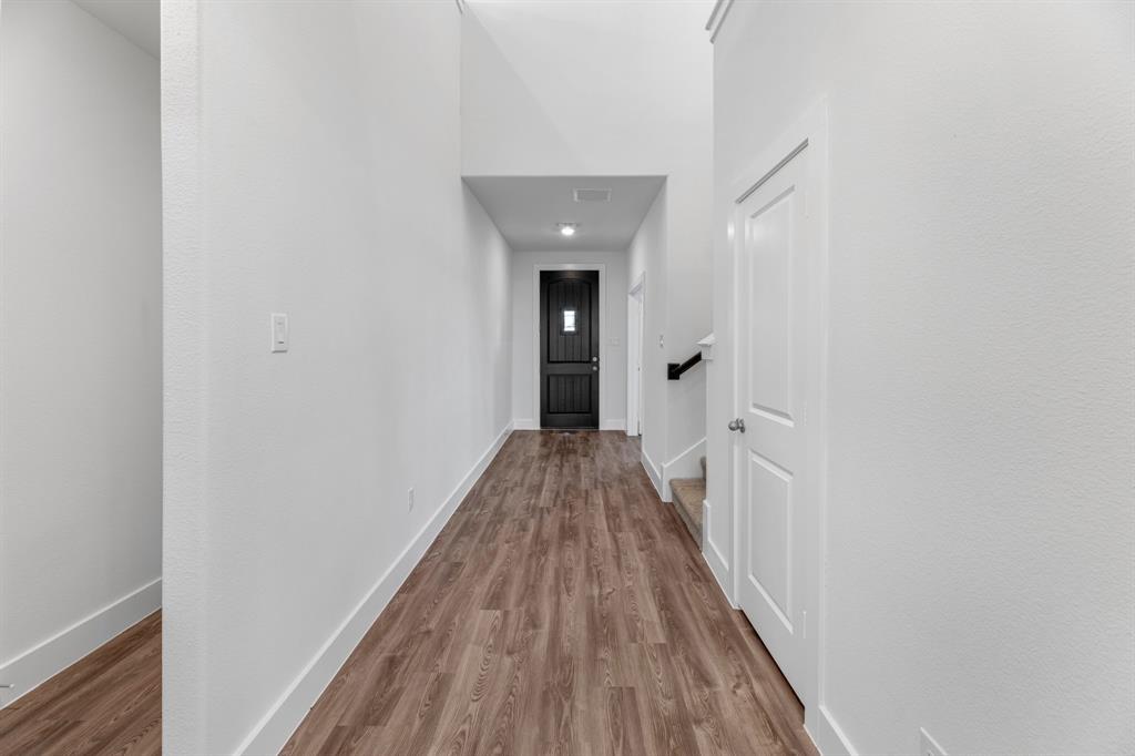 a view of a hallway with wooden floor and staircase