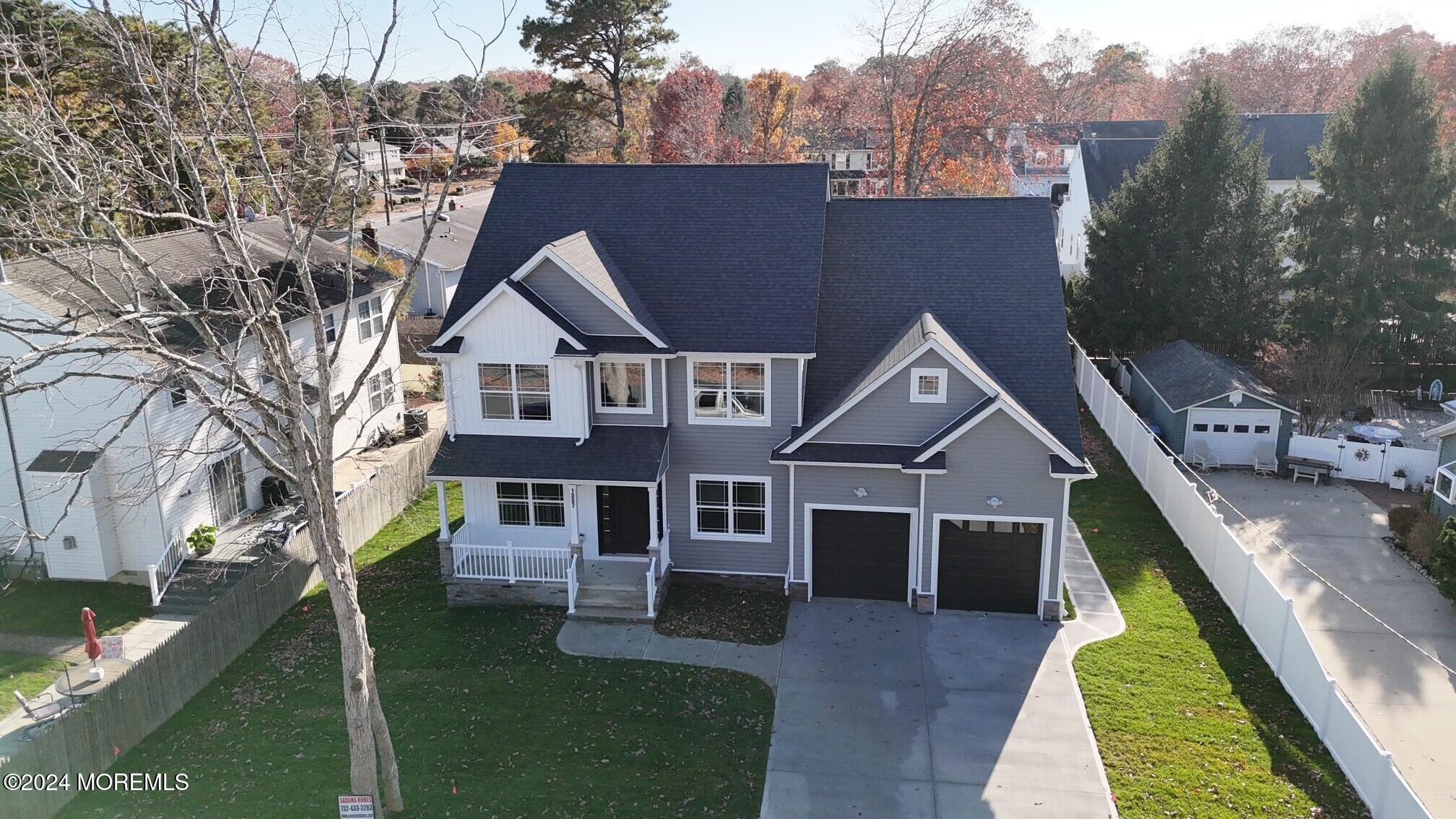 a aerial view of a house next to a big yard and large trees