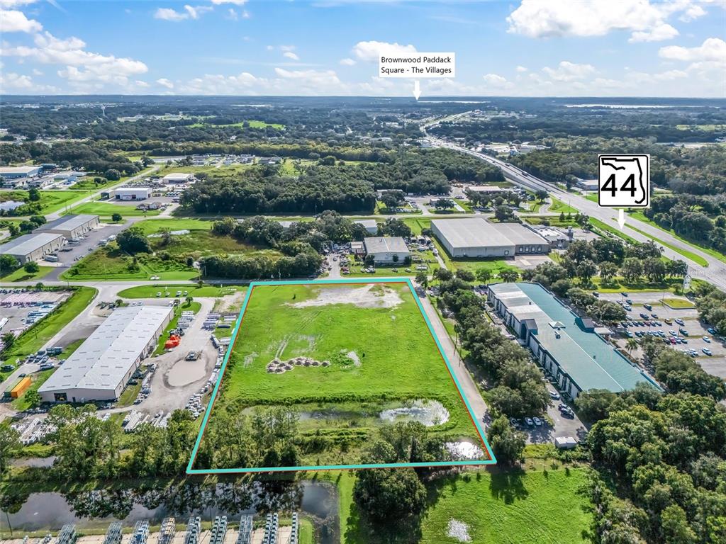 an aerial view of a tennis ground and a cars park side of the road