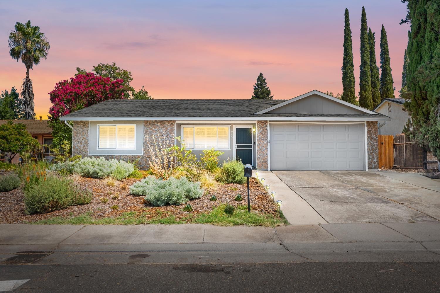 a front view of a house with a yard and potted plants