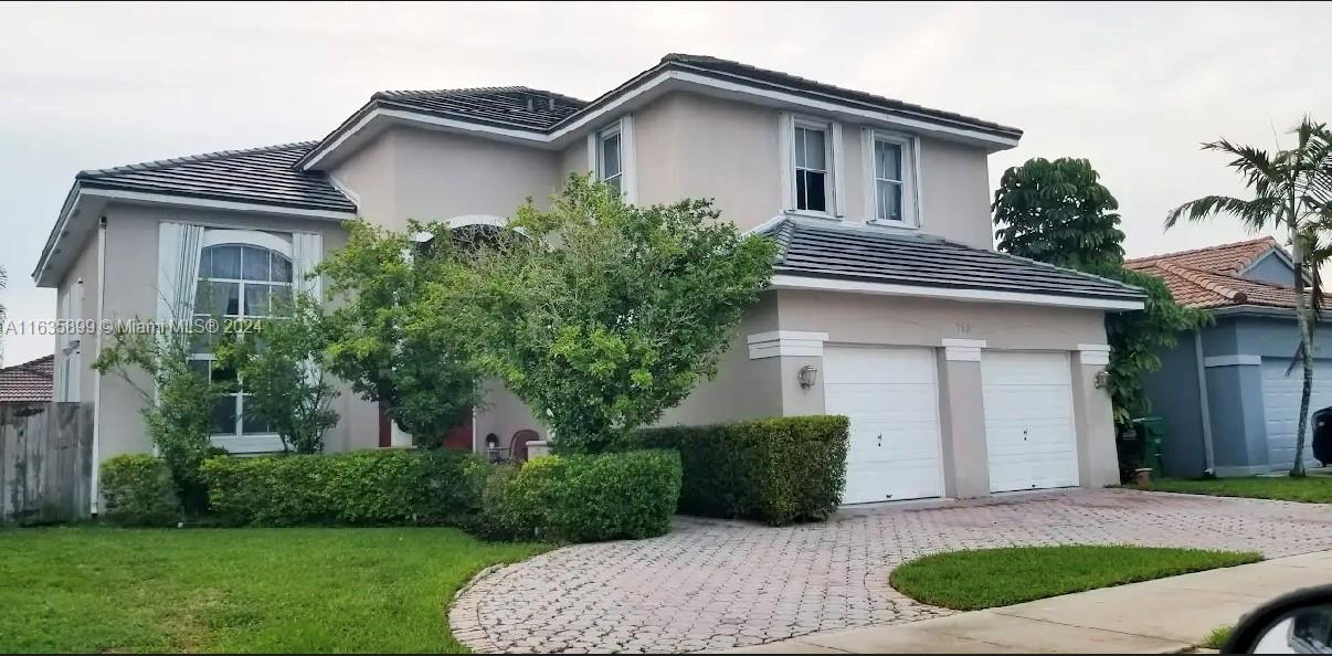 a front view of a house with a yard and garage