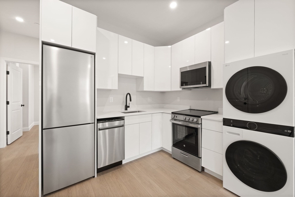 a kitchen with a refrigerator sink and cabinets