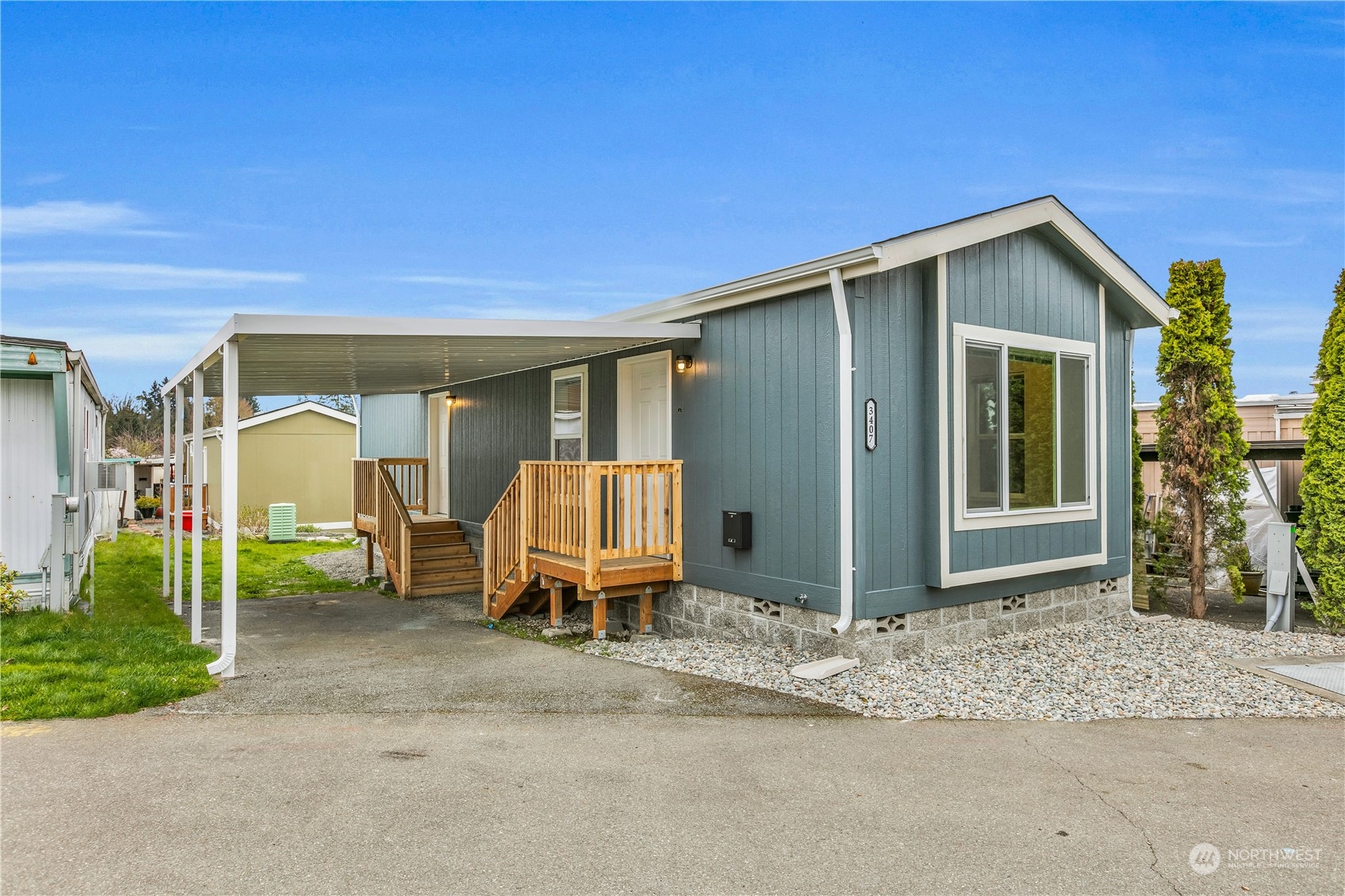 a view of backyard of house with wooden fence and a couple of lawn chairs