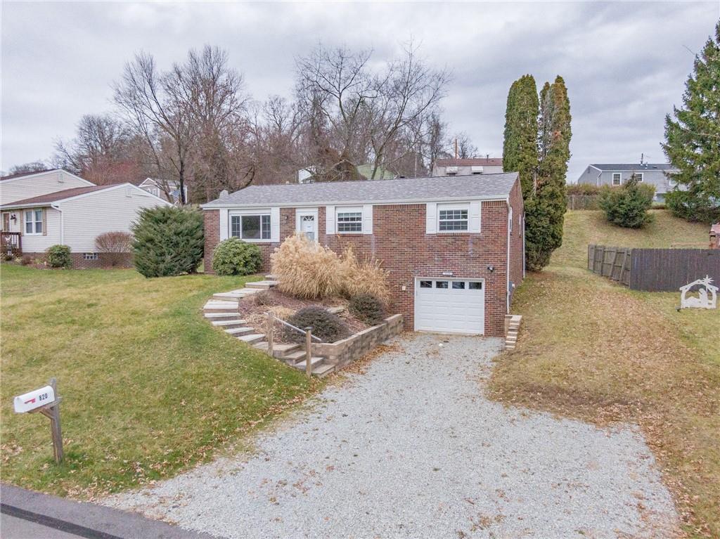 a view of a house with a yard and large tree