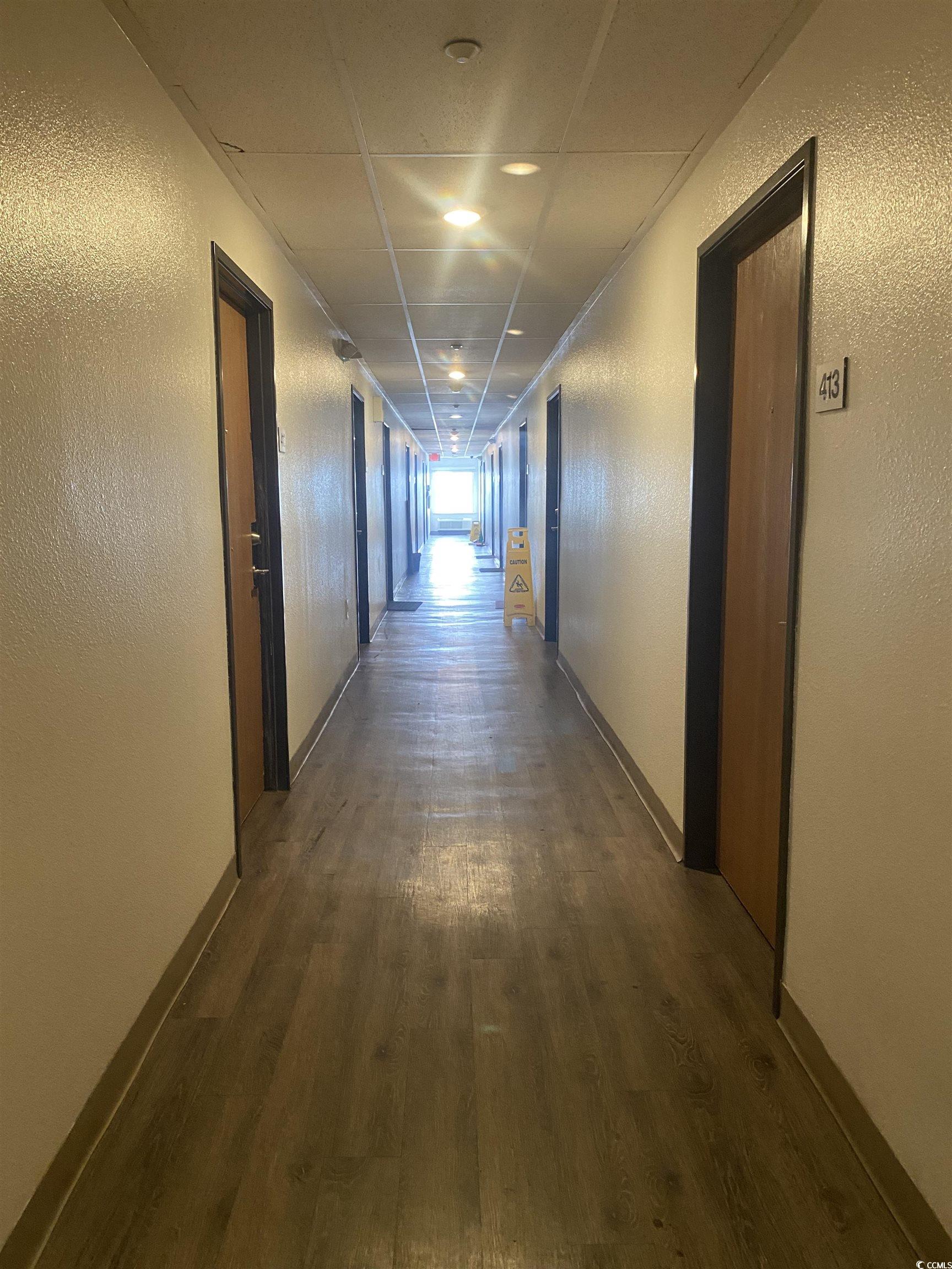 Corridor with dark hardwood / wood-style flooring