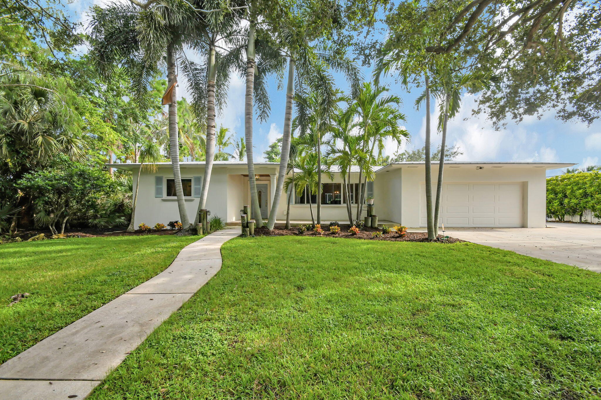 front view of a house with a yard and an trees