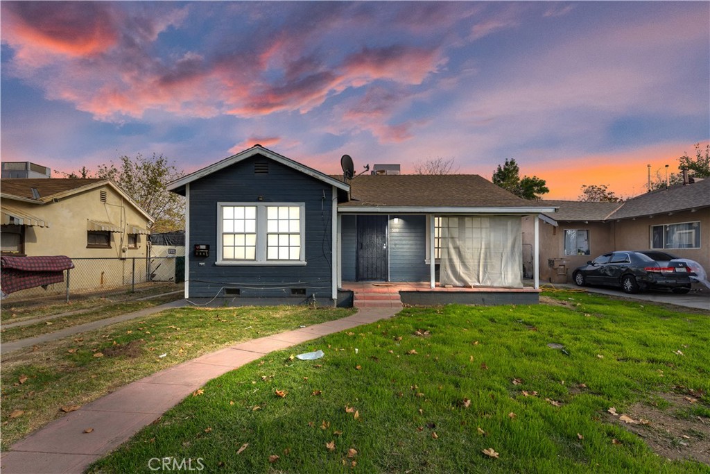 a view of a house with a patio and a yard