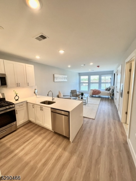 a large white kitchen with lots of counter space a sink and a stove