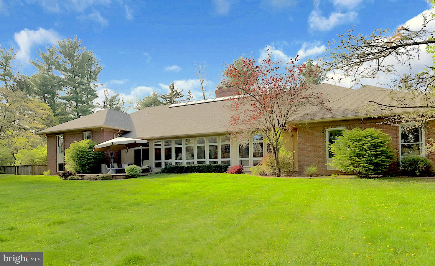 a view of a house with a big yard and large trees