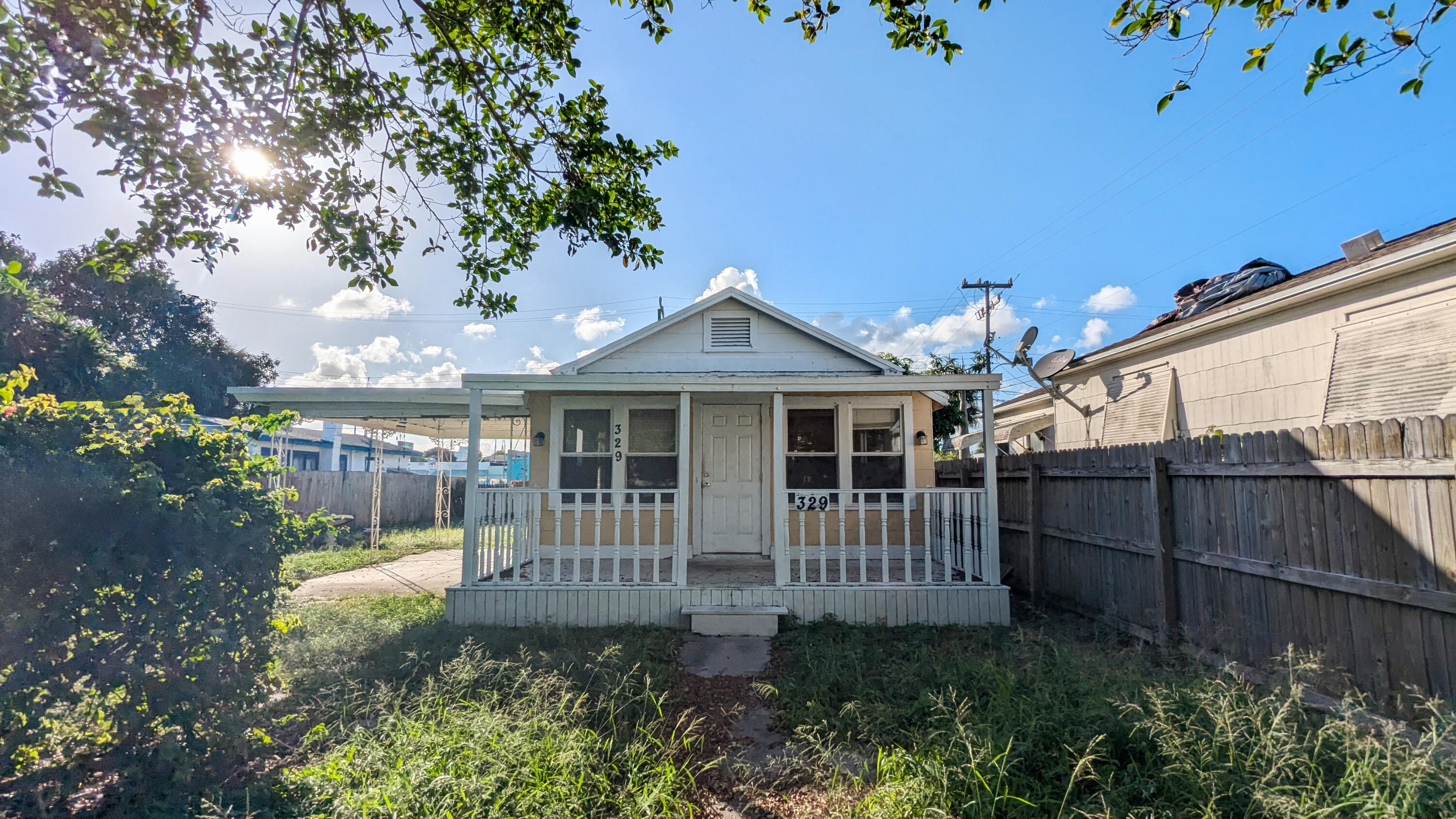 a view of a house with a small yard and wooden fence