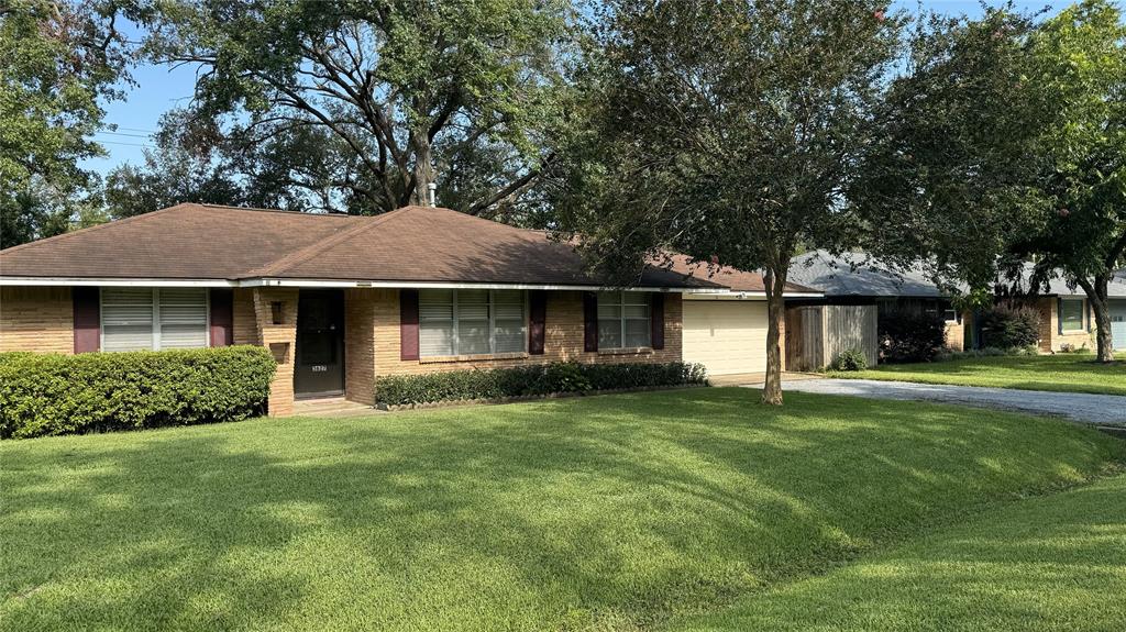 a front view of a house with a yard and trees