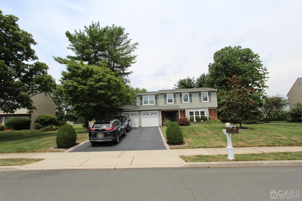 a front view of a house with a garden and parking