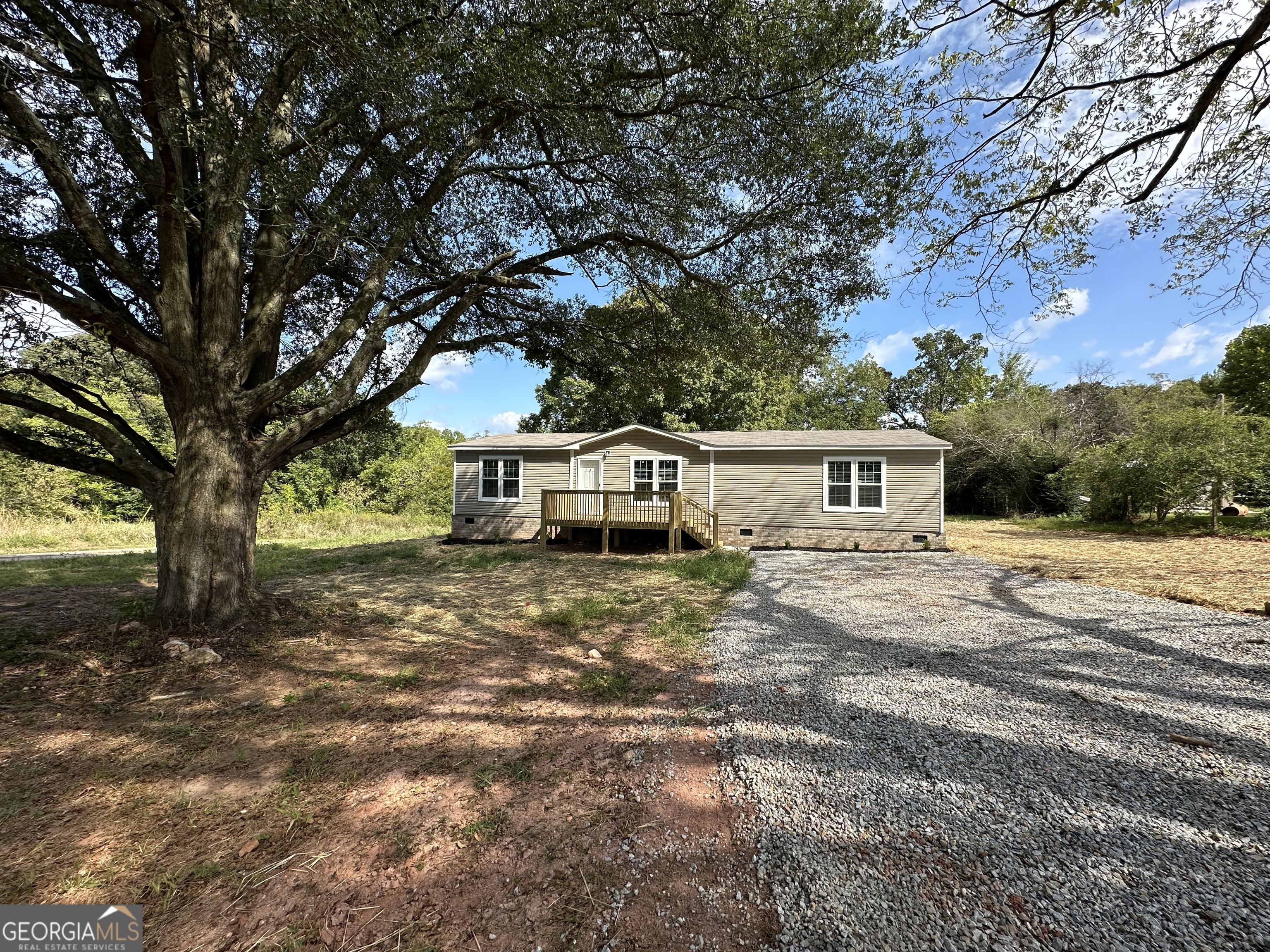 a front view of a house with a yard and trees