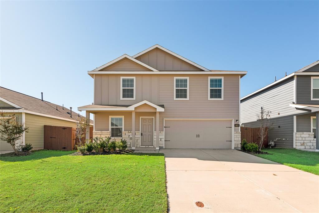 a front view of a house with a yard and garage