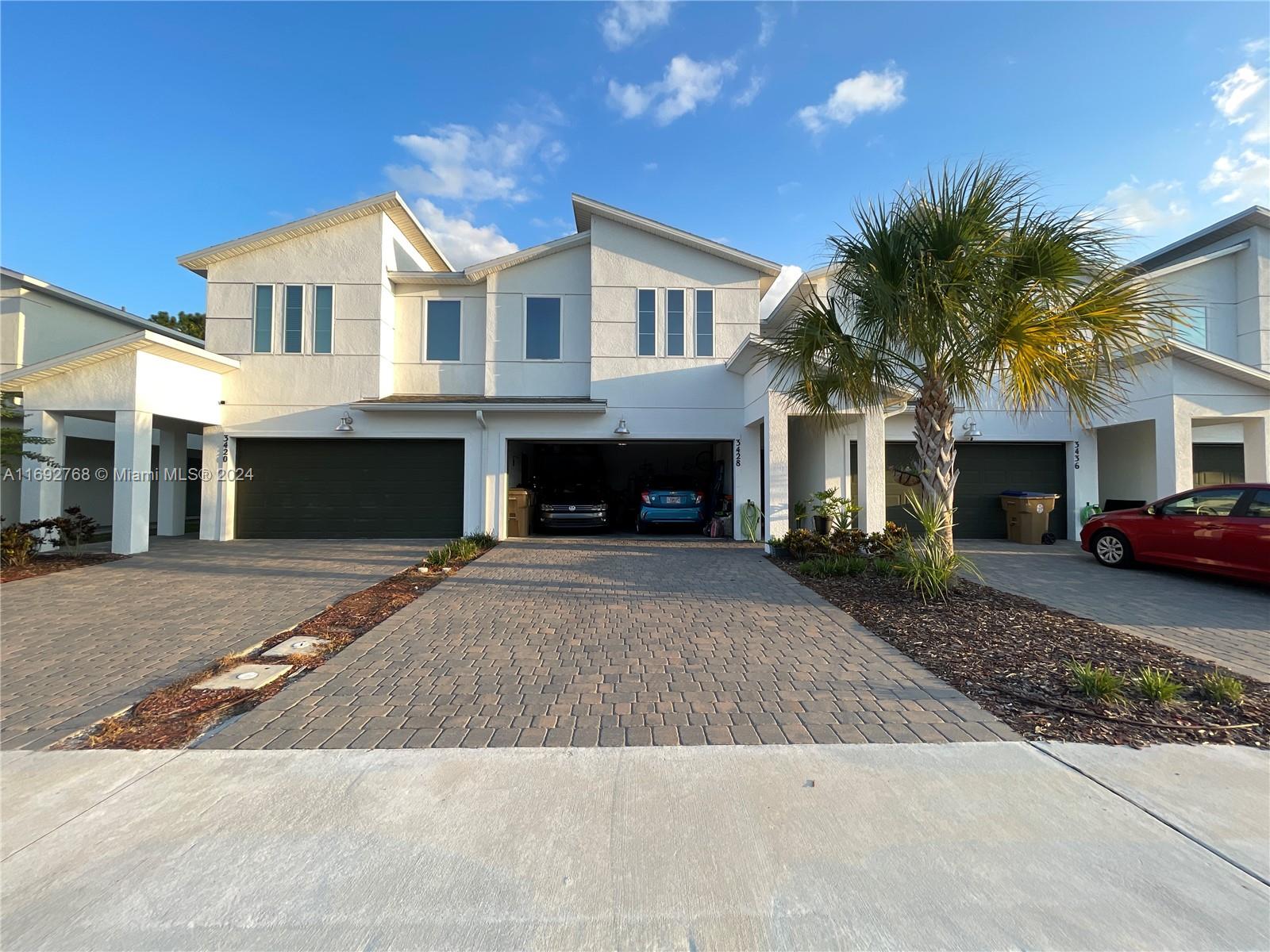 a front view of a house with yard and parking