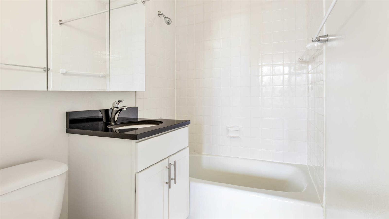 a bathroom with a sink a toilet and shower