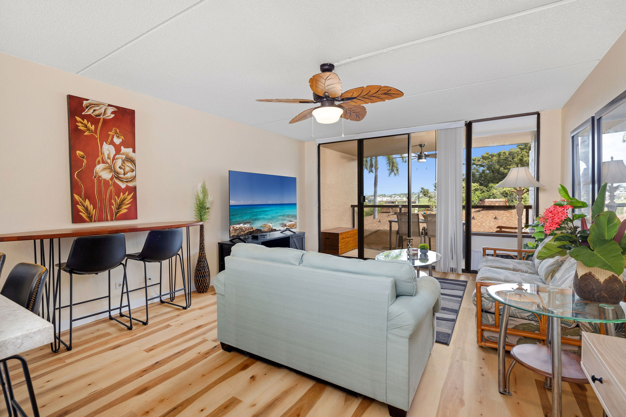 a living room with furniture a flat screen tv and a floor to ceiling window