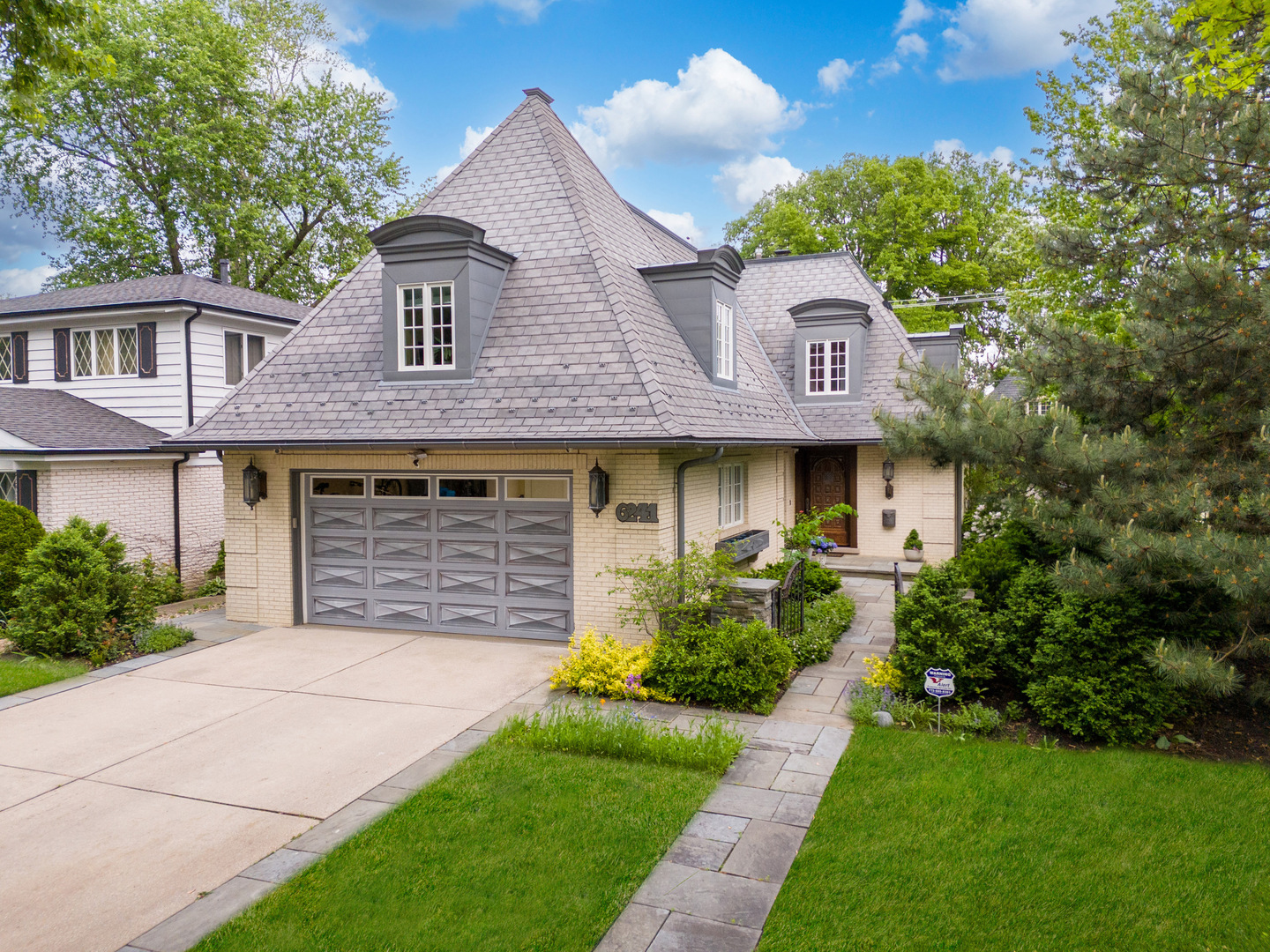 a front view of a house with a garden and plants