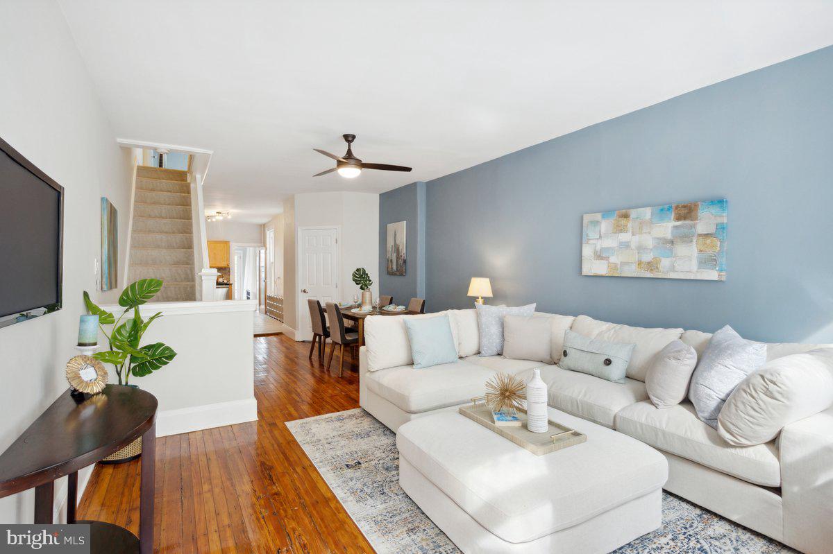 a living room with furniture and a wooden floor