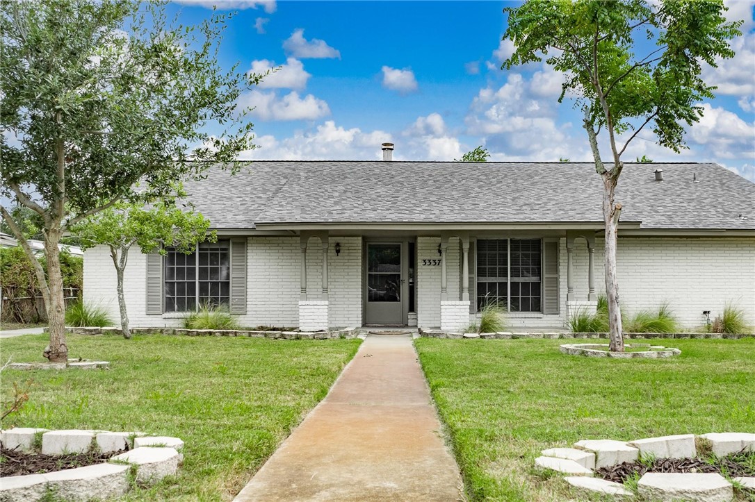 a front view of a house with a garden and plants