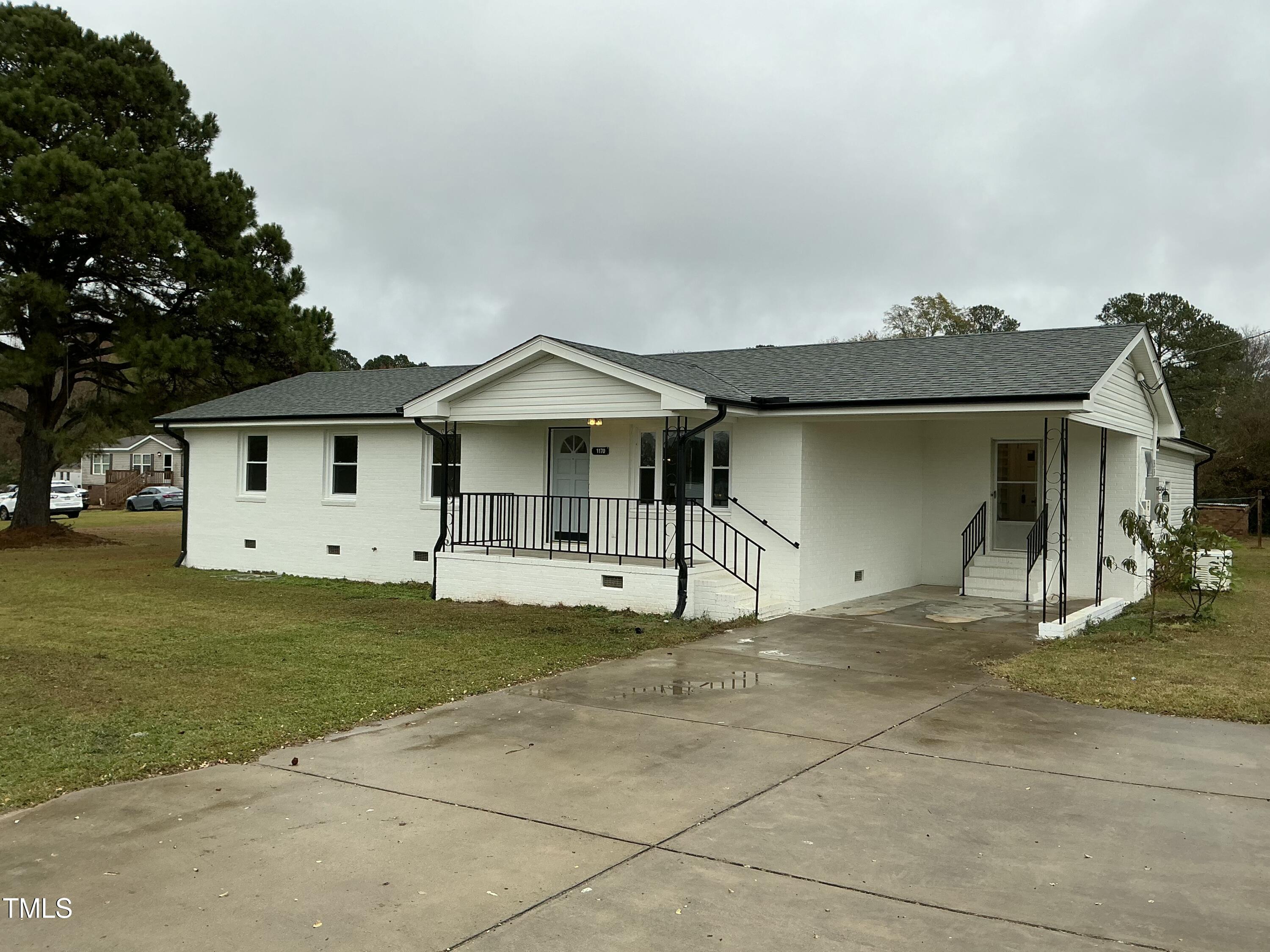 a front view of a house with a garden and yard