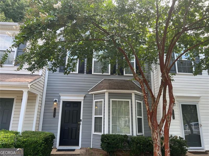 a front view of a house with a tree