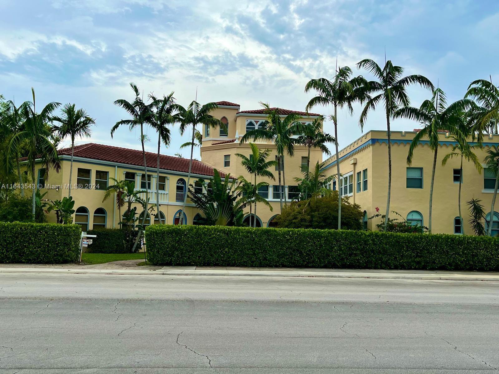 front view of house with a yard and potted plants