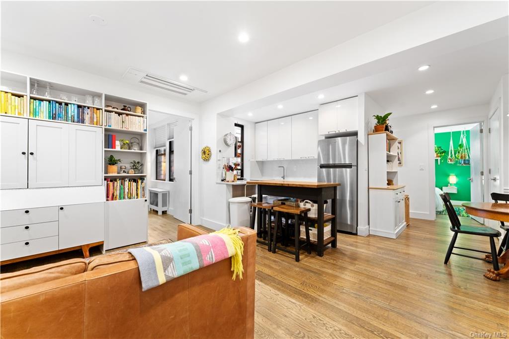 a living room with furniture and a dining table with wooden floor