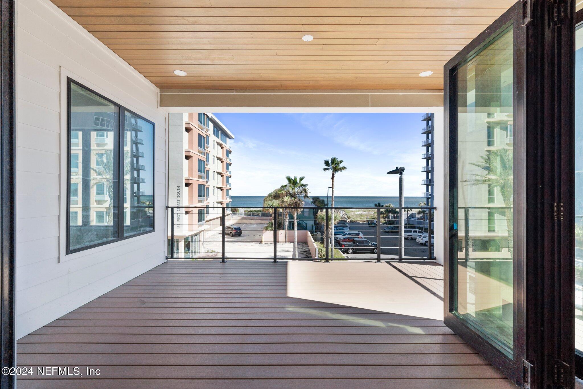 a view of a balcony with dining table chairs and wooden floor