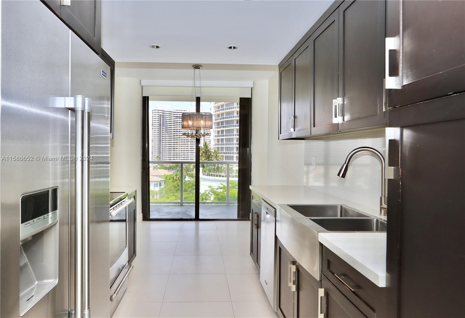 a kitchen with a sink a counter top space and stainless steel appliances