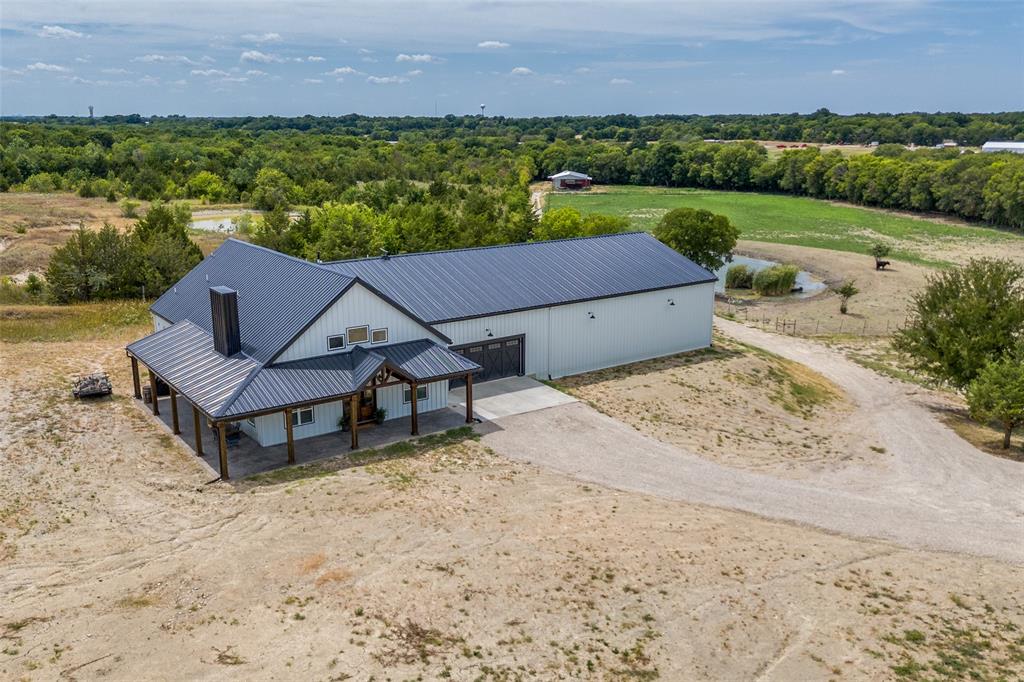 an aerial view of a house with a garden and lake view