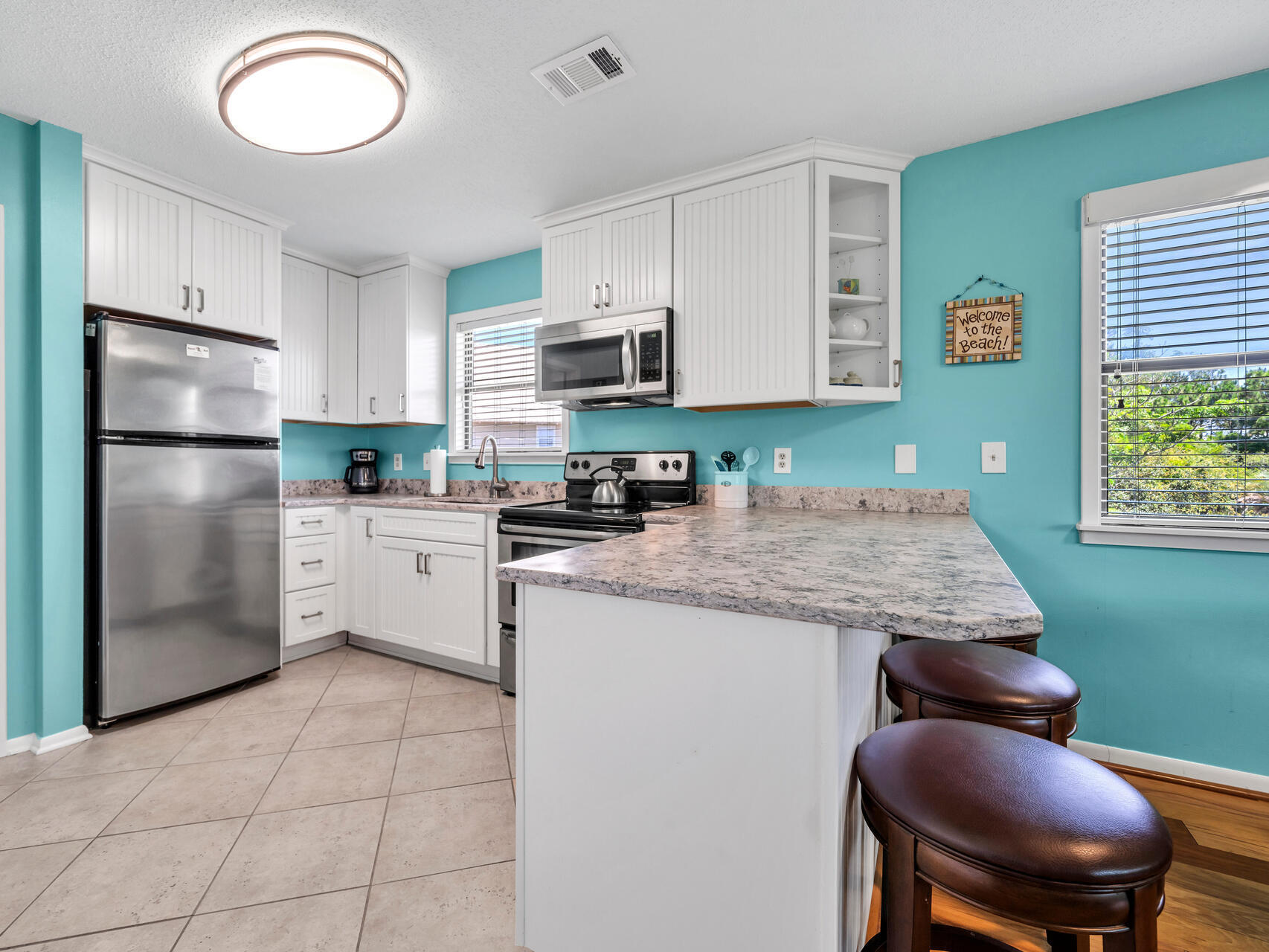 a kitchen with kitchen island granite countertop a stove refrigerator and sink